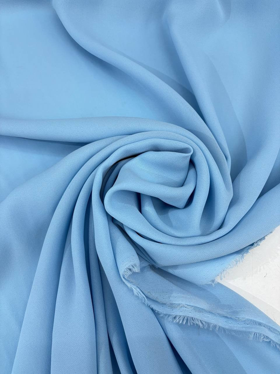 Dettaglio tessuto georgette tinta unita celeste polvere, trama leggera e leggermente trasparente
