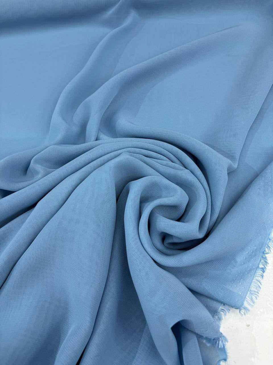 Dettaglio tessuto georgette tinta unita celeste, trama leggera e leggermente trasparente