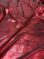 Dettaglio trama tessuto lycra rosso brillante effetto glitter per costumi da spettacolo