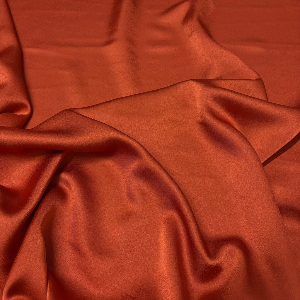 Satin raso manoseta arancione coccio, tessuto morbido e lucido per vestiti da sera