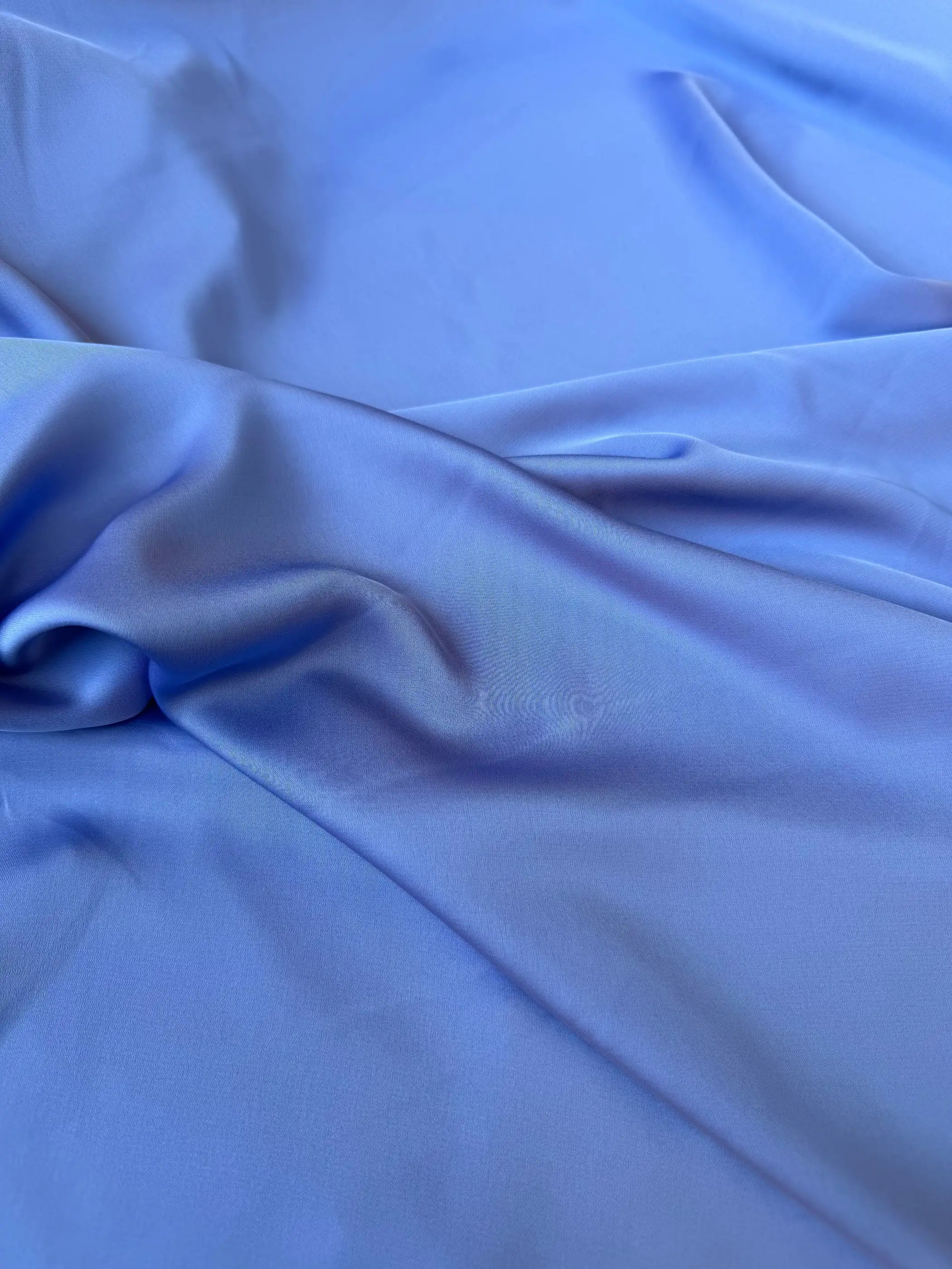 Dettaglio tessuto satin raso manoseta color lavanda, superficie liscia e luminosa per abiti eleganti