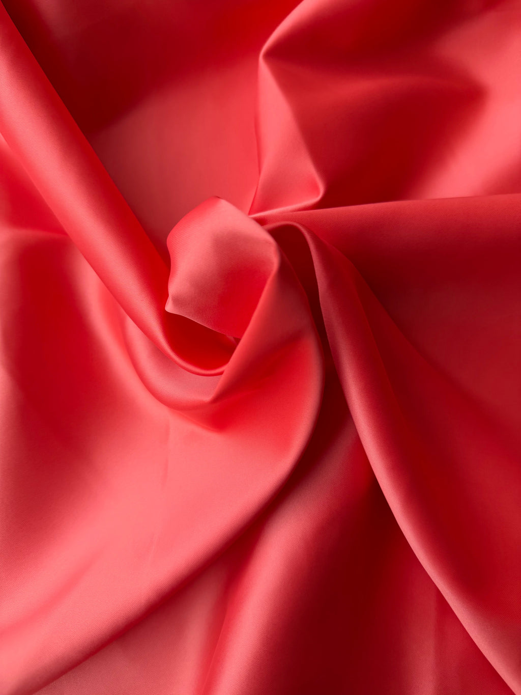 Tessuto doppio raso fluido corallo, elegante e setoso, perfetto per abiti e capi sartoriali
