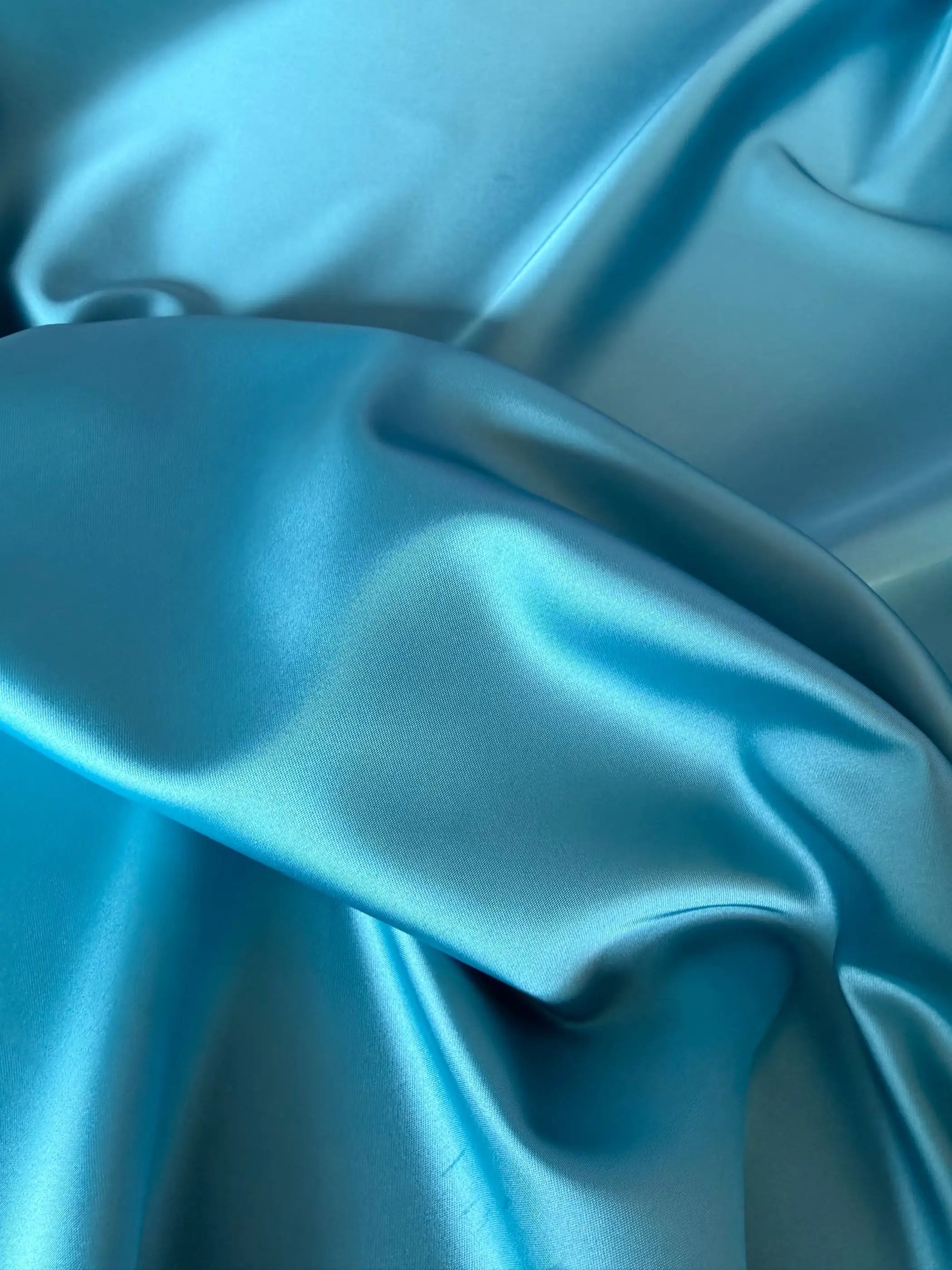 Tessuto doppio raso fluido turchese, elegante e setoso, perfetto per abiti e capi sartoriali