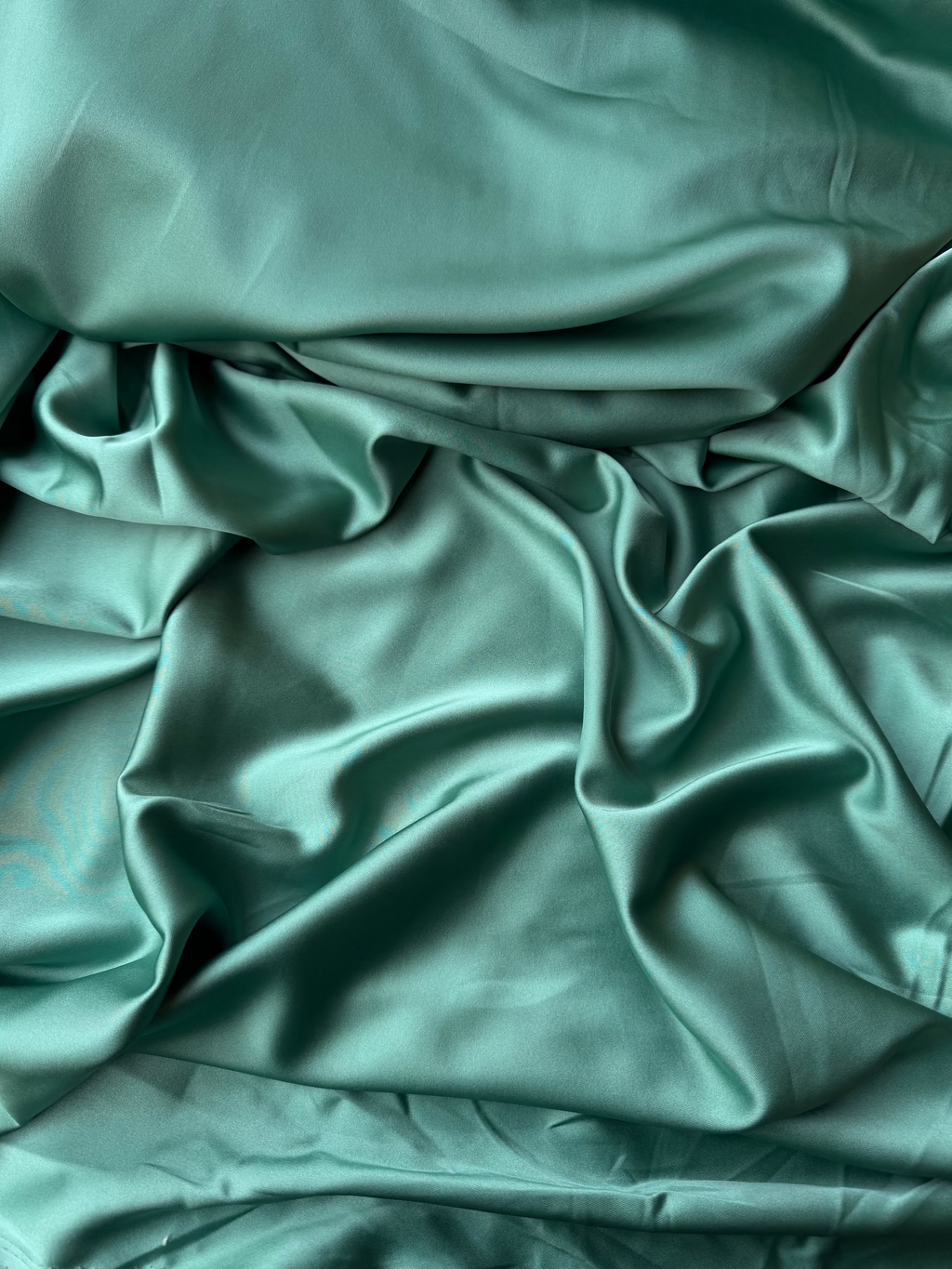 Tessuto doppio raso fluido verde salvia, elegante e setoso, perfetto per abiti e capi sartoriali